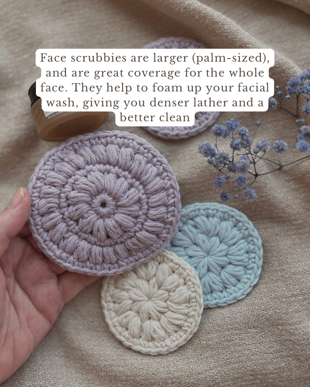 Three crocheted face scrubbies in purple, blue, and beige on a textured surface with text overlay.