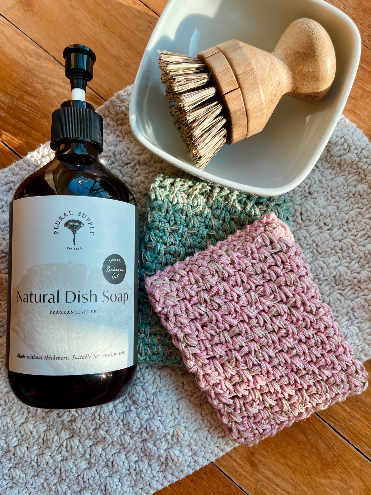 2 recycled cotton reusable dish sponges with bamboo brush and natural dish soap, placed on top of cotton dish cloth, natural materials, plastic free, non toxic, natural, environmentally friendly kitchen tools