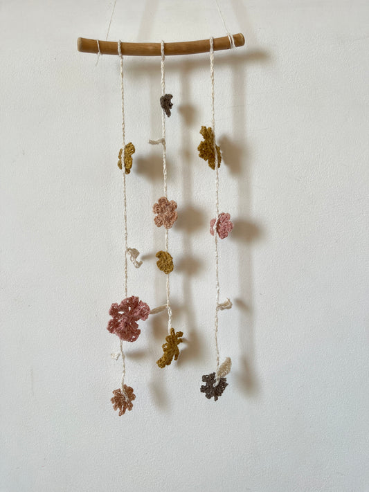 Decorative string of crochet small flowers and leaves on a white background